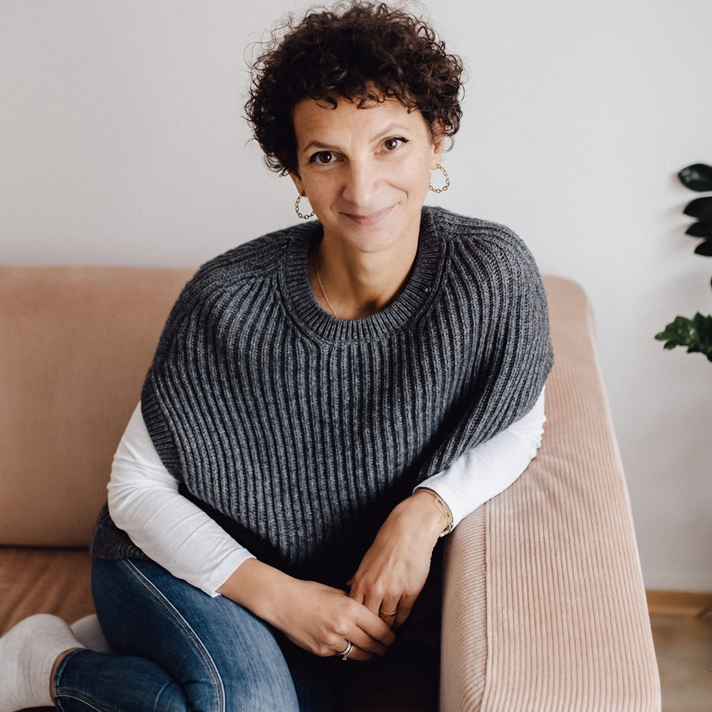 SinnKraft Manuela Christl auf Sofa sitzend